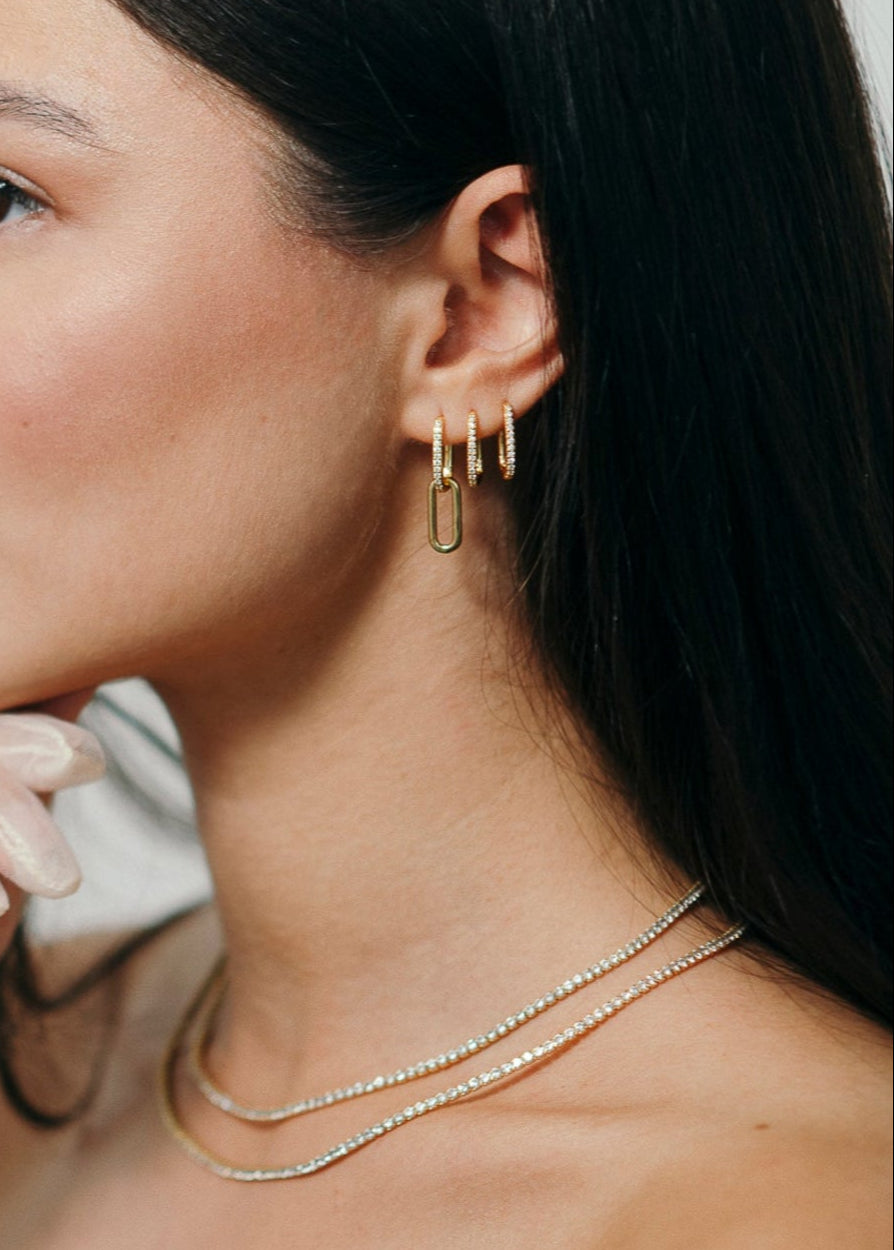 Frau mit Creolen Seven und Twentyfour bestehend aus 18 Karat Vergoldung und 925 Sterlingsilber