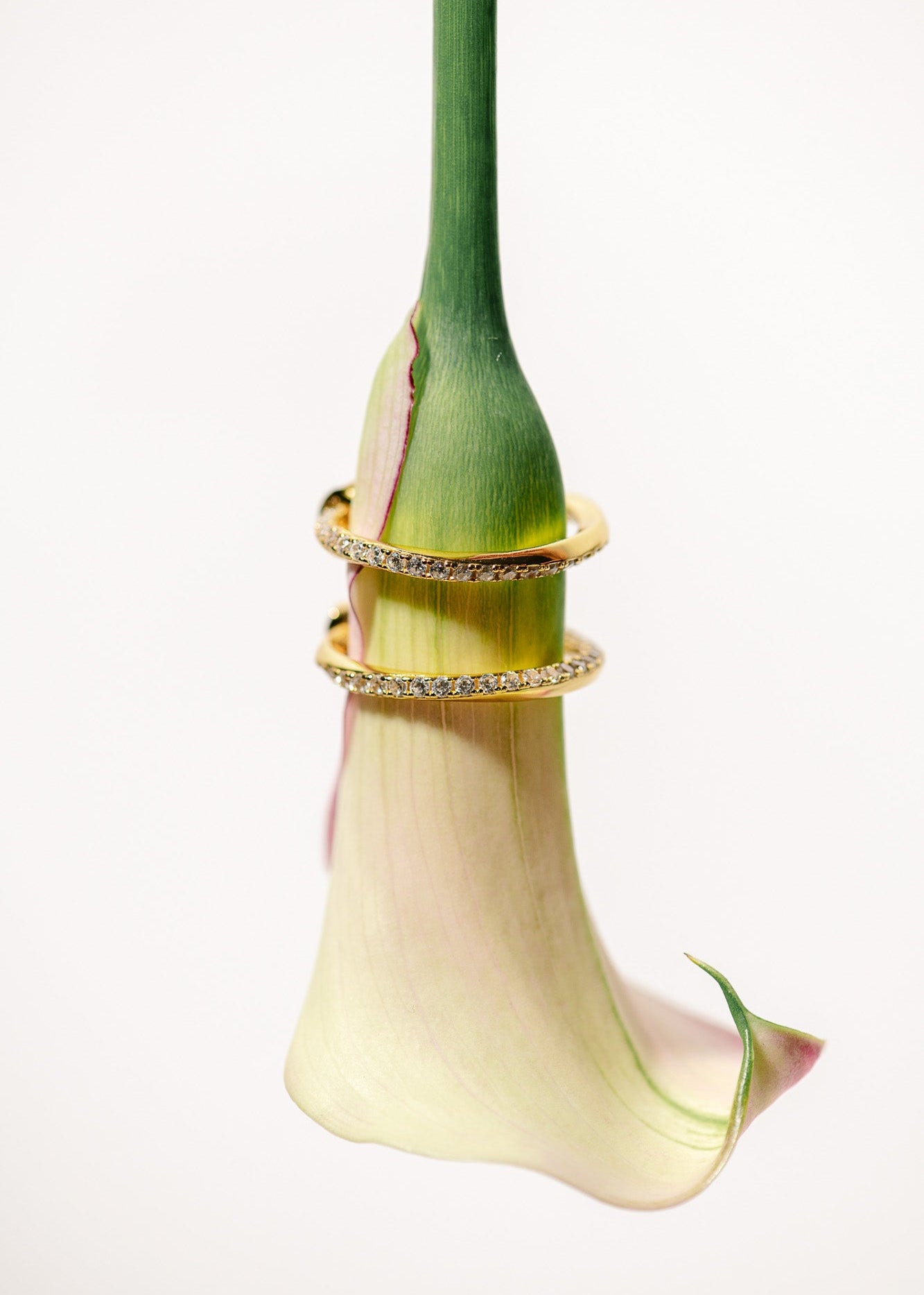 Orbit Ohrringe sind Creolen mit verdrehten Zirkonia Steinen entlang des Ohrrings. Die Halbcreolen bestehen aus 18K Vergoldung und 925 Sterlingsilber der Marke Mobijou