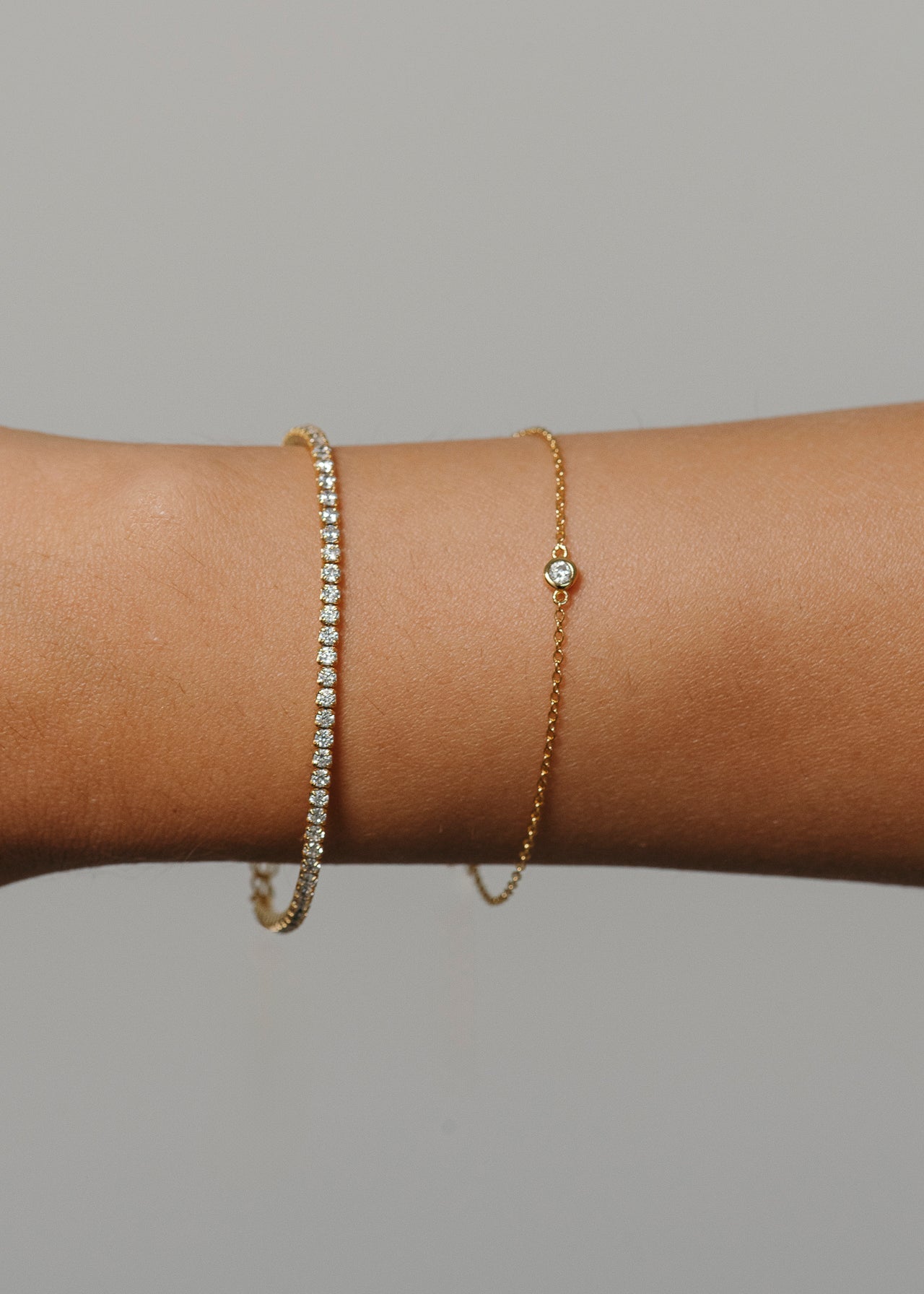 Tragebild von einem Tennisarmband und Plain Armband mit einem Zirkoniastein. Beide Armbänder sind hochwertig und dezent 